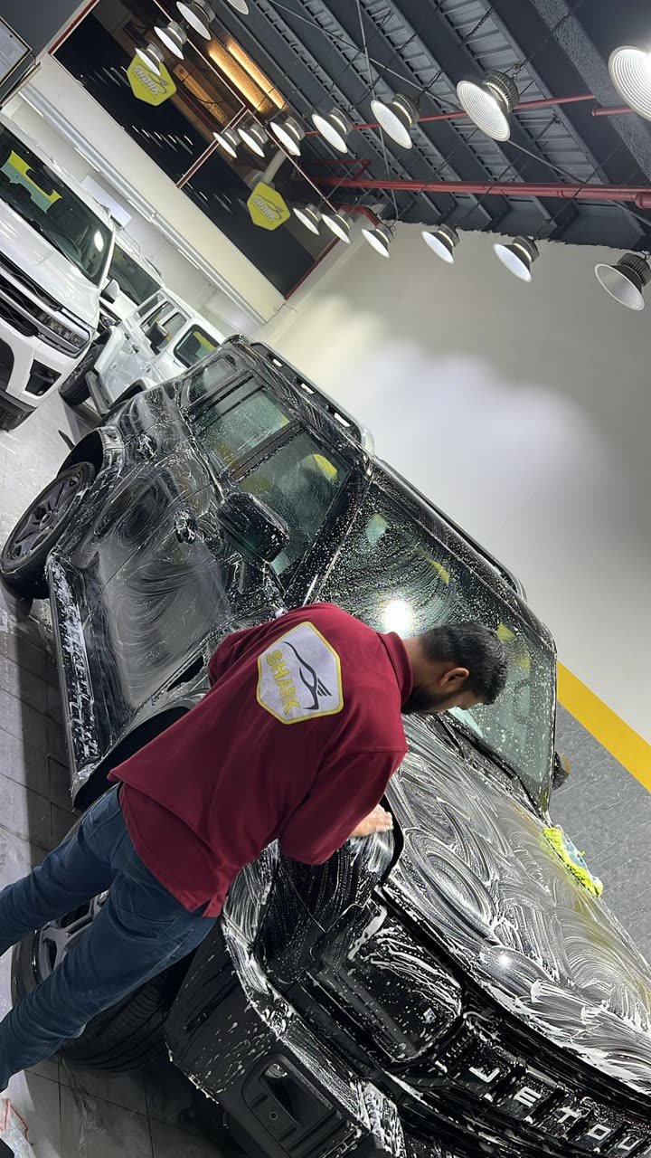 Technician washing a vehicle during prep