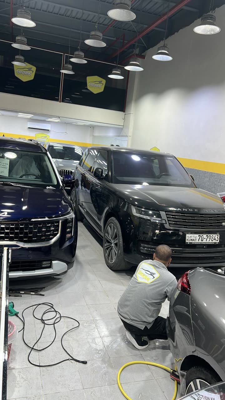 Technicians working on a Range Rover in the bay