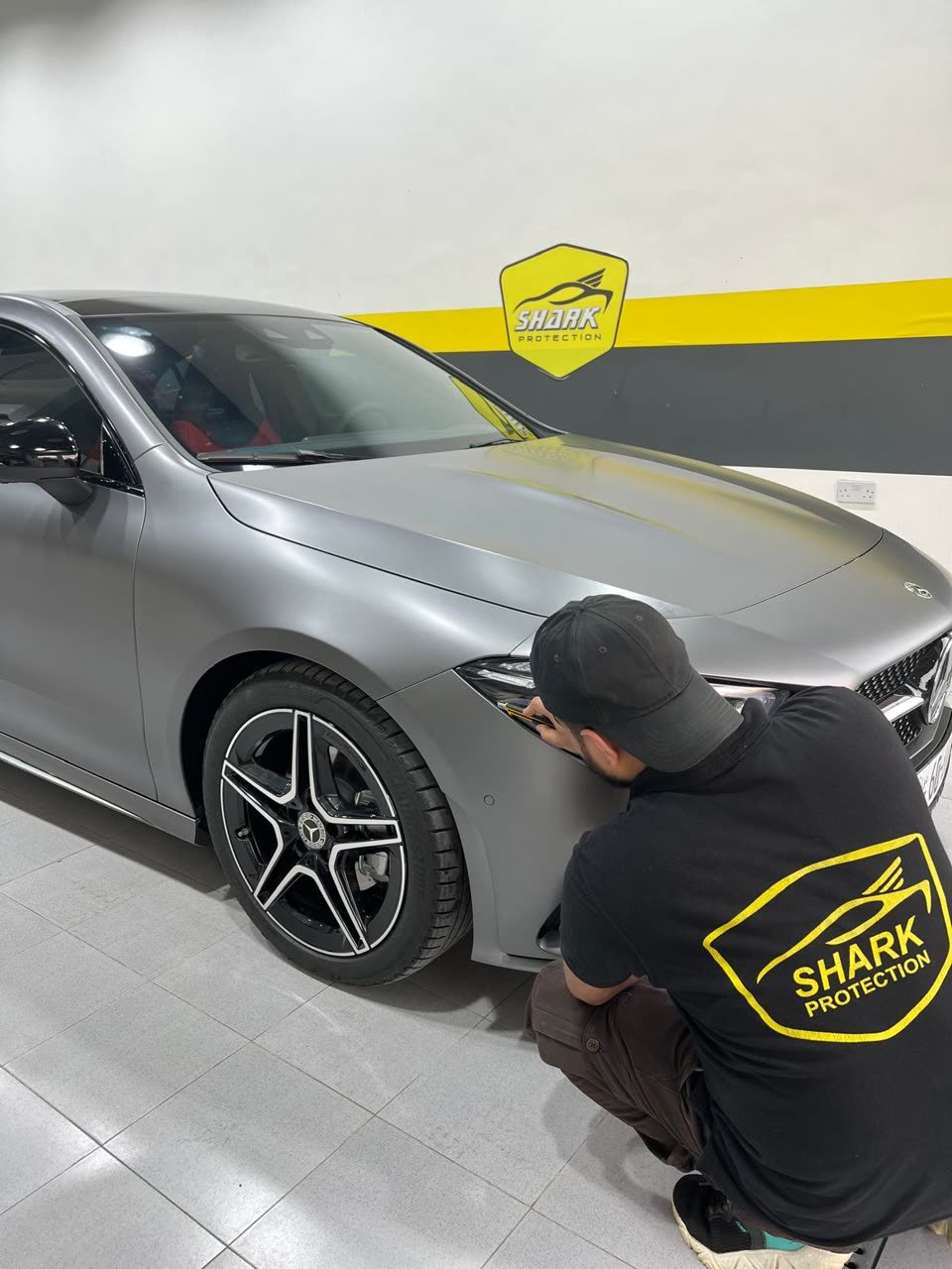 Matte-wrapped Mercedes being finished by a technician