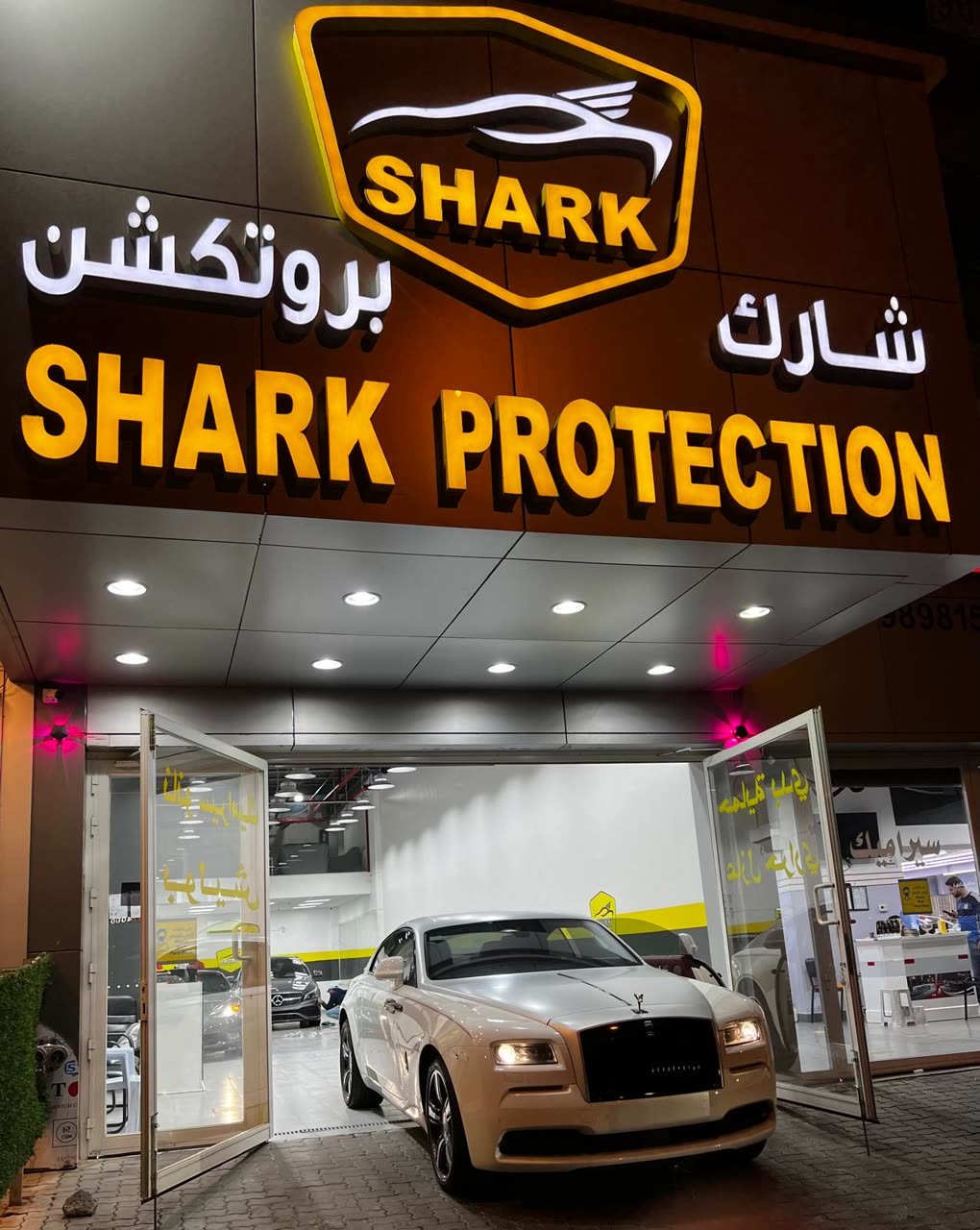 Rolls-Royce Wraith at the Shark Protection KW storefront at night